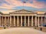 Fachada principal del British Museum con columnas jónicas bajo un cielo al atardecer