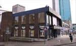Vista exterior del Alexandra Theatre en Birmingham mostrando su fachada moderna y ubicación urbana