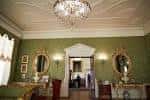 Sala interior elegante con lámpara de cristal y paredes verdes decoradas