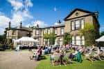 Vista exterior de Lotherton Hall con evento al aire libre y decoración festiva