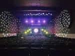 Interior del auditorio del Woodlawn Theatre con escenario iluminado y butacas vacías