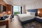 Habitación de hotel con cama king-size, escritorio y vista a la ciudad
