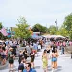 Vista exterior del patio de Land-Grant Brewing Company con gente disfrutando de un evento al aire libre