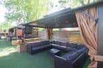Área de lounge al aire libre con sofás y toldo en el patio de Land-Grant Brewing