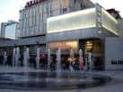 Vista exterior nocturna del Lyric Hammersmith Theatre con fachada iluminada y fuente en primer plano