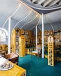 Sala interior con estanterías de madera y diseño orgánico en el techo