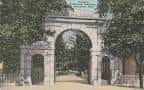 Puerta de piedra histórica del cementerio con vegetación circundante