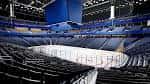 Vista interior del Benchmark International Arena con pista de hielo y gradas azules
