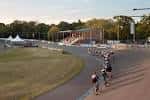 Vista exterior del velódromo con ciclistas en acción durante el atardecer