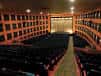 Interior del auditorio con butacas y escenario frente al público