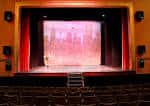 Escenario principal con cortinas rojas y telón decorativo