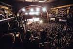 Concierto en vivo con público lleno y luces de escenario encendidas