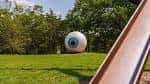 Ojo gigante blanco en el parque con tobogán en primer plano