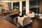 Suite ejecutiva con vistas nocturnas a la ciudad desde grandes ventanales