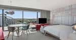 Suite moderna con cama king-size, zona de trabajo y vistas panorámicas al exterior
