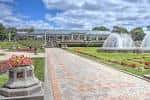 Vista panorámica del parque con invernaderos y fuentes en primer plano
