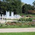 Fuente central rodeada de jardines floridos y senderos peatonales
