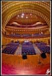 Vista panorámica del interior del auditorio con butacas azules y techo ornamentado