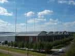 Vista exterior del English Institute of Sport en Sheffield con cielo azul y banderas