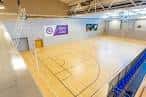 Pista de baloncesto interior del EIS Sheffield con líneas marcadas y paredes blancas