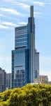 Vista exterior del Comcast Technology Center desde un parque con árboles en primer plano