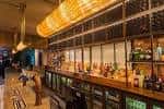 Interior moderno del bar con barra larga y estanterías de botellas