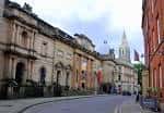 Vista exterior del National Justice Museum en Nottingham con su fachada histórica y la torre de la catedral al fondo