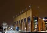 Vista nocturna del NCAA Hall of Champions con fachada iluminada y banderas