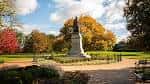 Monumento central en Schiller Park rodeado de jardines y follaje otoñal