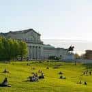 Vista exterior del Saint Louis Art Museum con césped y personas relajándose