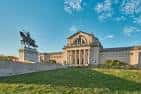 Fachada principal del museo con estatua ecuestre al frente bajo cielo azul