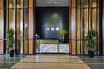 Recepción moderna del lobby con acabados en madera y plantas decorativas