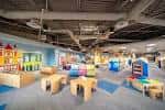 Área infantil de la biblioteca con juguetes y mobiliario colorido