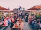 Vista del rooftop bar de Headrow House con gente disfrutando en mesas al atardecer