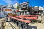 Vista exterior del patio de Tennessee Brew Works con mesas altas y murales