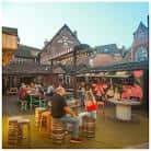 Terraza exterior del The Old Crown con clientes disfrutando de bebidas y ambiente festivo