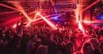 Interior del Hangar 34 con iluminación de luces rojas y multitudes
