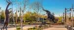 Área exterior del zoo con esculturas de animales y senderos peatonales
