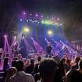 Concierto en vivo en el interior del venue con luces de escenario y público