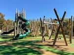 Área de juegos infantiles con estructuras modernas y toboganes verdes