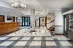 Lobby principal del hotel con suelo de mosaico y recepción