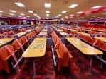 Interior de la sala de bingo con mesas y sillas naranjas