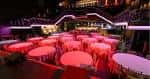 Sala de eventos configurada con mesas redondas y sillas para una recepción o cena