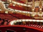 Vista panorámica del auditorio con butacas rojas y arquitectura clásica