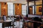 Interior acogedor del pub con mesas, sillas y decoración cálida junto a ventanas