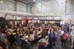Interior del Cains Brewery Village con ambiente festivo y público asistiendo a eventos