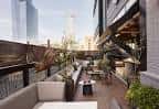 Terraza exterior con mobiliario moderno y vistas a la ciudad
