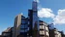 Torre moderna del edificio con diseño de cristal y hormigón bajo cielo azul