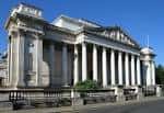 Vista exterior del Museo Fitzwilliam con fachada neoclásica y columnas bajo cielo azul