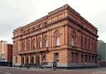 Vista exterior de la Biblioteca Central de Belfast con fachada neoclásica en ladrillo rojo